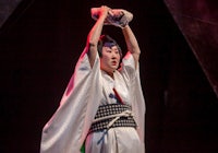 a woman in a kimono is holding a ball in her hands