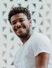 a young man in a white t - shirt smiling